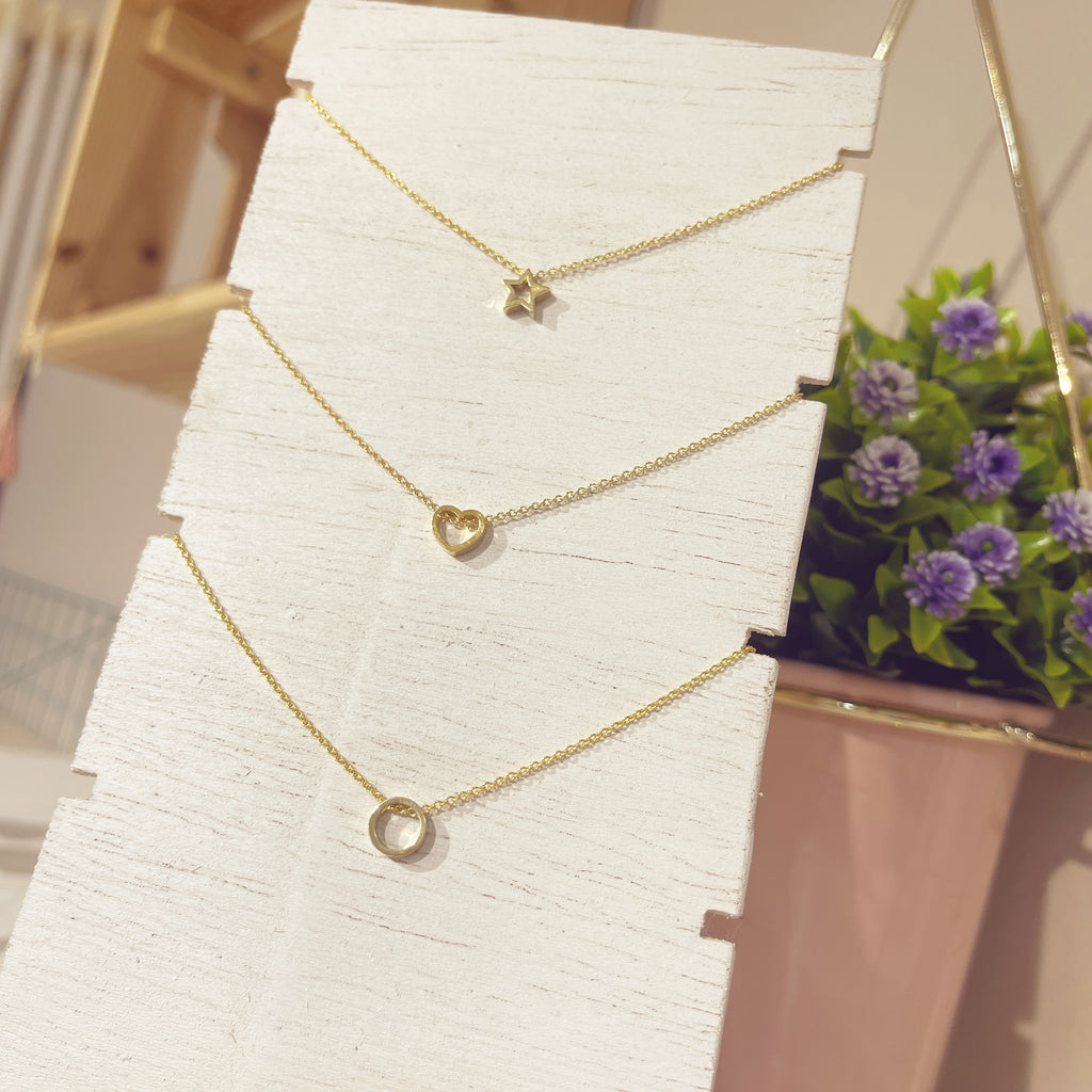 Collar Estrella Nova junto a collar corazón y collar círculo dorados