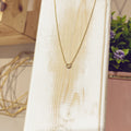 Collar Herradura Mini pavé dorada en expositor blanco