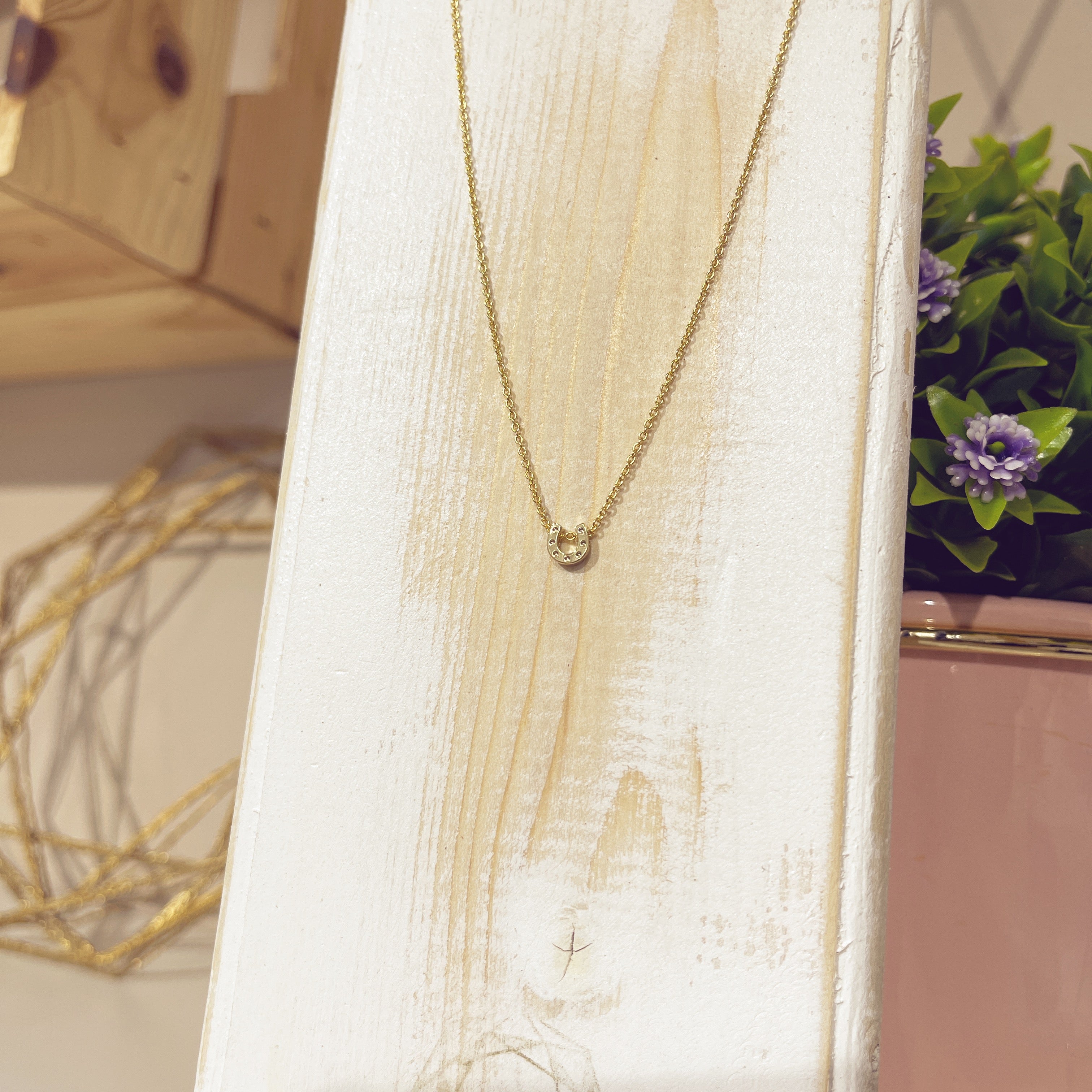 Collar Herradura Mini pavé dorada en expositor blanco