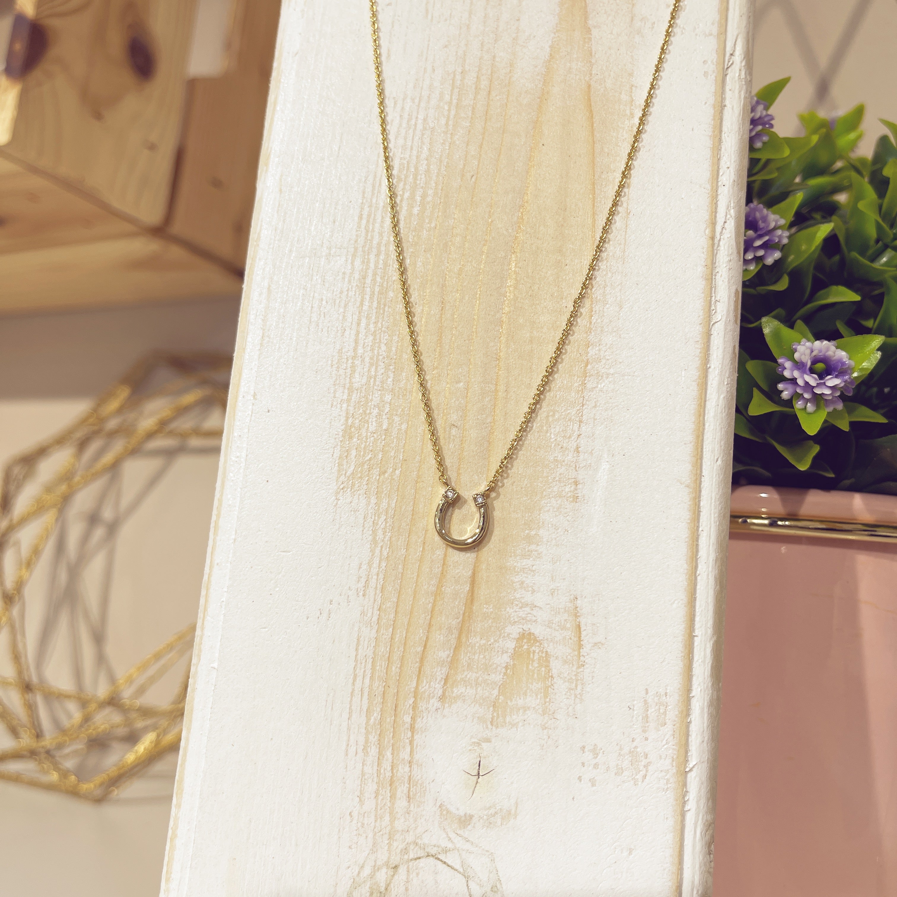 Collar Herradura Circón dorada en expositor blanco