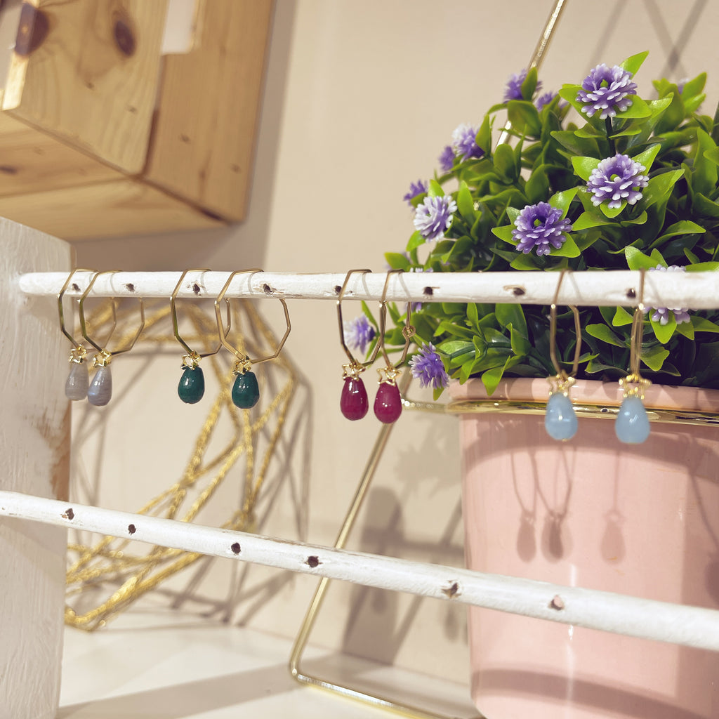 Colección aros rombo mineral en varios colores colgados en expositor