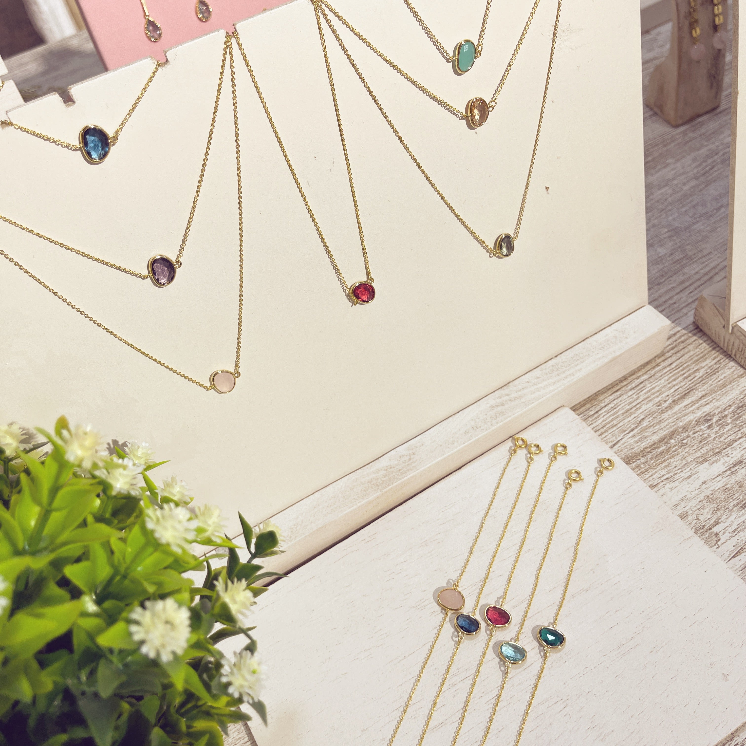 Colección pulseras y collares Piedra Doblada dorados con piedras de colores en expositor