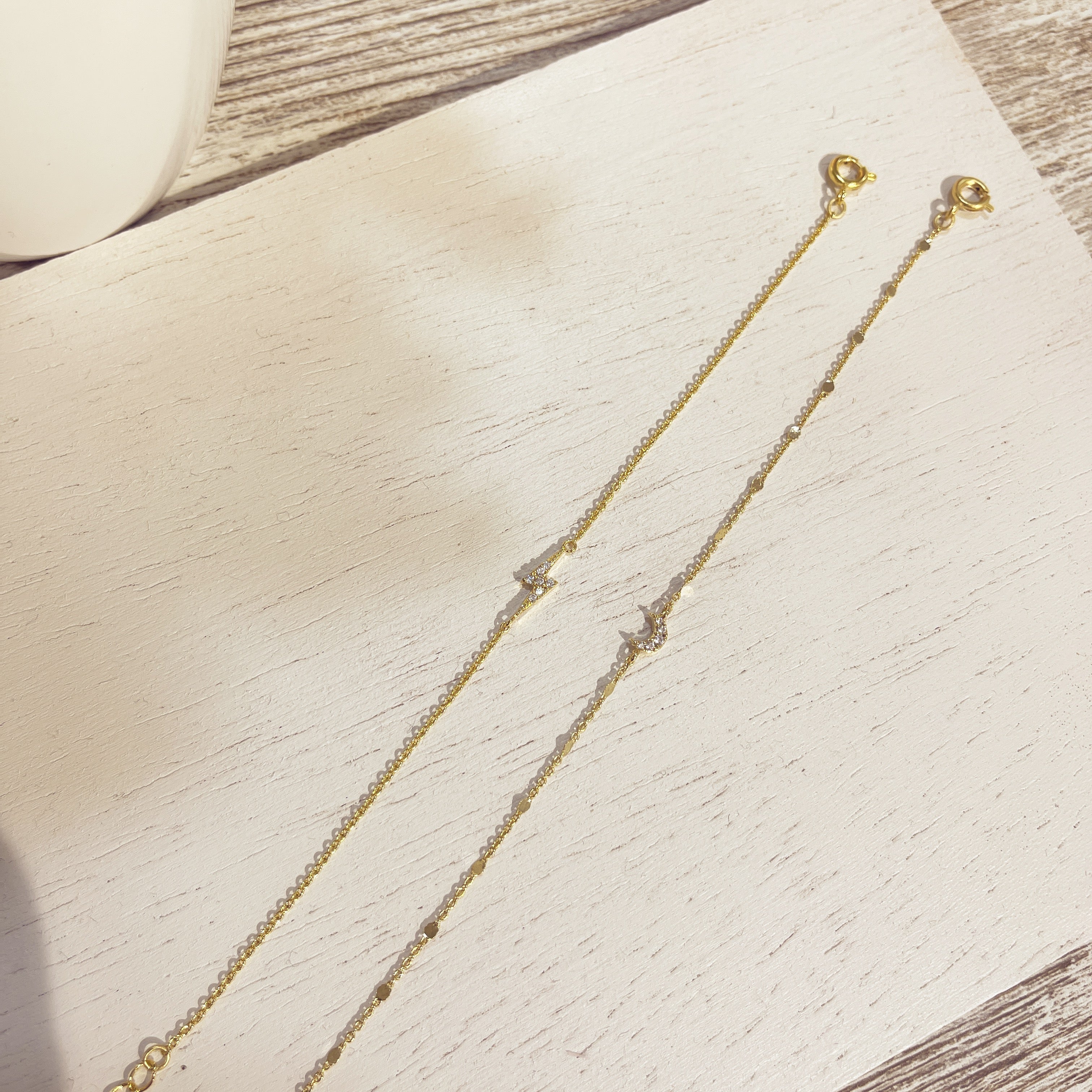 Pulseras Luna Circón doradas sobre superficie blanca