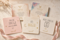 Tarjetas Stella Doré con relieve dorado sobre fondo crema con cinta rosa
